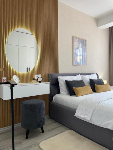 a bedroom with a bed and a round mirror at Apartment Prizreni-Free Private Parking in Prizren