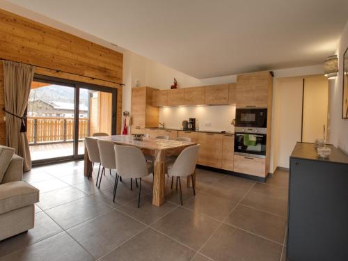 une cuisine avec une table et des chaises dans une pièce dans l'établissement Bel appartement neuf 8 pers près du village avec Wifi et garage - FR-1-642-100, à Samoëns