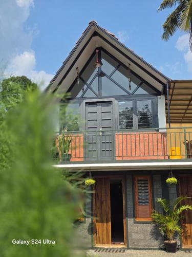 ein Haus mit einem großen Fenster darüber in der Unterkunft Moon Glade Service Villa in Mananthavady
