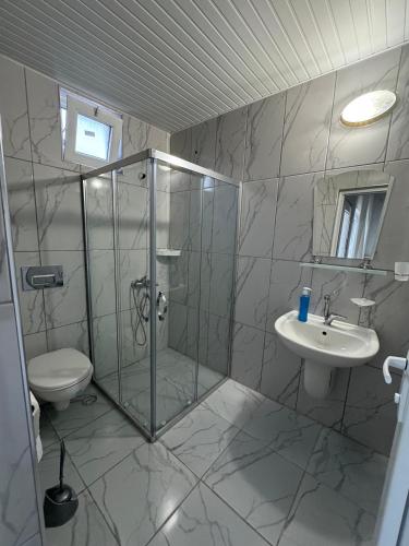 a bathroom with a shower and a toilet and a sink at Atlas Bungalows in Kumluca