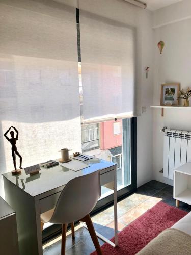 a room with a desk and a large window at Suíte Campo de Ourique - Art and Comfort in Lisbon