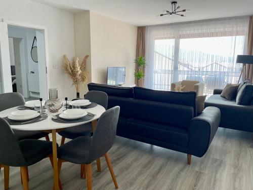 a living room with a blue couch and a table at Apartment Prizreni-Free Private Parking in Prizren
