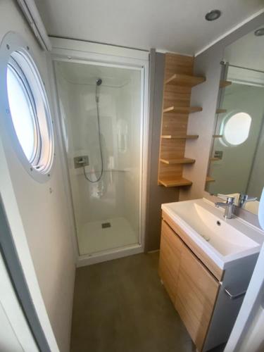 une salle de bain avec douche et lavabo dans l'établissement Mobil home camping Marisol toreilles, à Torreilles