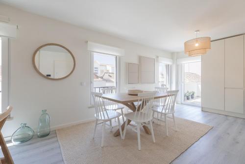 a dining room with a table and chairs and a mirror at Peniche Hideout in Peniche