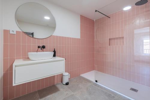 a bathroom with a sink and a tub and a mirror at Peniche Hideout in Peniche