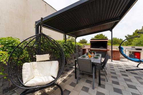 a patio with a swing and a table and chairs at MY DALMATIA - Apartment Nikita with private pool in Zaboric