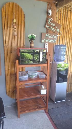 a microwave sitting on a shelf next to a refrigerator at Siam Flora Resort Koh Lanta in Ko Lanta