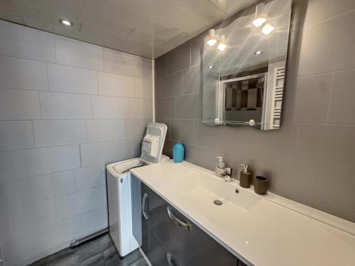 une salle de bain avec un lavabo et une machine à laver dans l'établissement Le Mimosa, à Cavalaire-sur-Mer