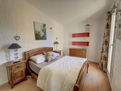 une petite chambre avec un lit et deux tables de nuit dans l'établissement Le Mimosa, à Cavalaire-sur-Mer