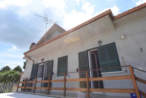 a white building with green shutters on it at Guest House Rossetto & Caffè in Colle di Fuori