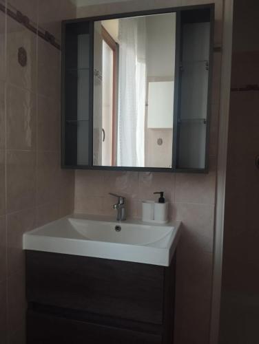 a bathroom with a white sink and a mirror at Cozy House in Civitavecchia
