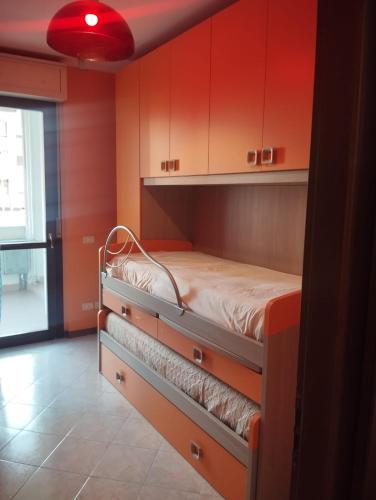 a bed in a room with red walls and cabinets at Cozy House in Civitavecchia