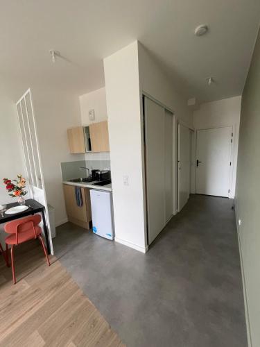 un appartement vide avec une table et une cuisine dans l'établissement Bright and peaceful studio with extendable bed, à Palaiseau