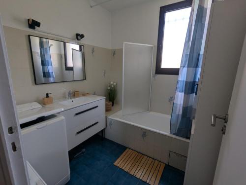 une salle de bain avec une baignoire, un lavabo et une douche dans l'établissement Appartement six personnes proche de la mer, à Six-Fours-les-Plages