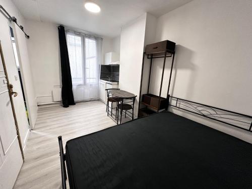 une chambre avec un lit, une table et une chaise dans l'établissement Belle Bellot appart 1 room Paris center, à Paris