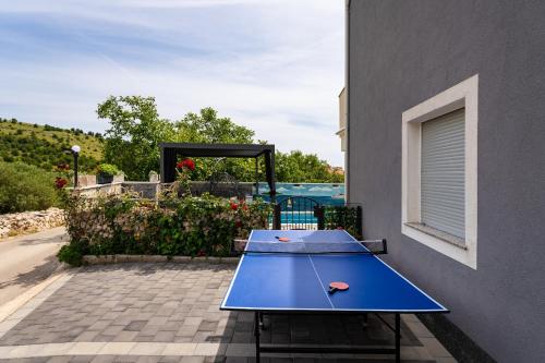 a blue ping pong table with two tennis balls on it at MY DALMATIA - Apartment Nikita with private pool in Zaboric