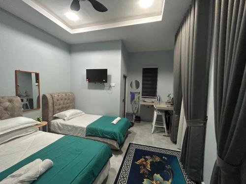 a hotel room with two beds and a desk at chalet jasa rajin in Kuala Terengganu