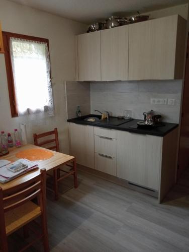 une cuisine avec une table et un comptoir dans l'établissement Appartement BOIS D'AMONT, à Bois-dʼAmont