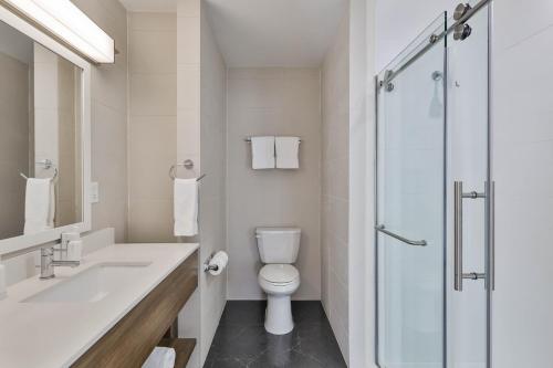 a white bathroom with a toilet and a shower at The Penn Stroud, Stroudsburg - Poconos, an Ascend Collection Hotel in Stroudsburg