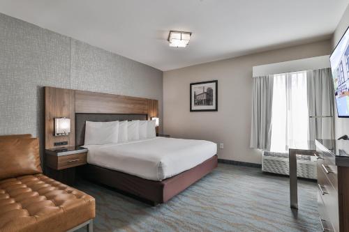 a hotel room with a bed and a couch at The Penn Stroud, Stroudsburg - Poconos, an Ascend Collection Hotel in Stroudsburg