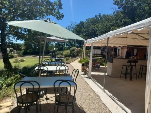 a group of tables with chairs and an umbrella at Domaine la cheneraie in Mirabel