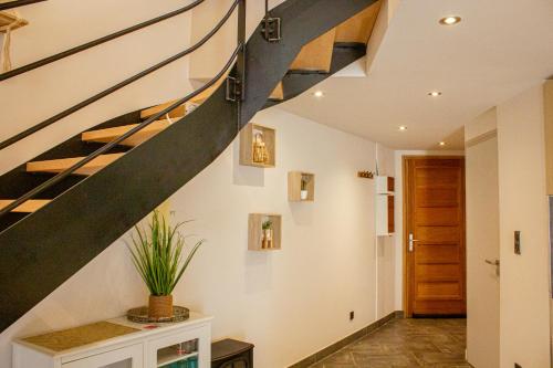 a staircase in a house with a potted plant at ADB - parking, balcon et centre ville in Albertville