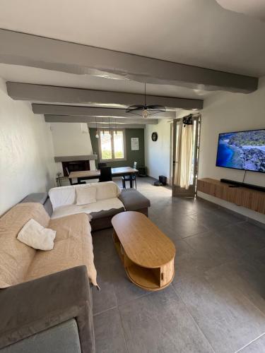 un salon avec un canapé et une table dans l'établissement La Tobynette, à LʼIsle-sur-la-Sorgue