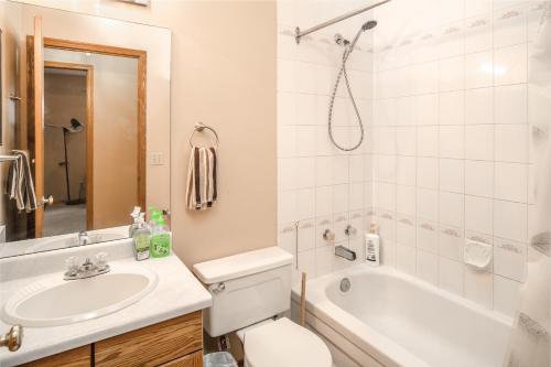 a bathroom with a sink and a toilet and a tub at Airport 4BR2BA Mainfloor Suite 1min walk to bus stop in Calgary