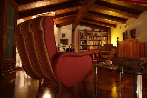 a living room with a red chair and a table at Akasamia B&B - La Dimora in Itri
