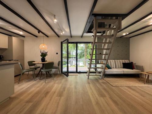 a living room with a staircase and a couch and a table at Domek na górce in Rańsk