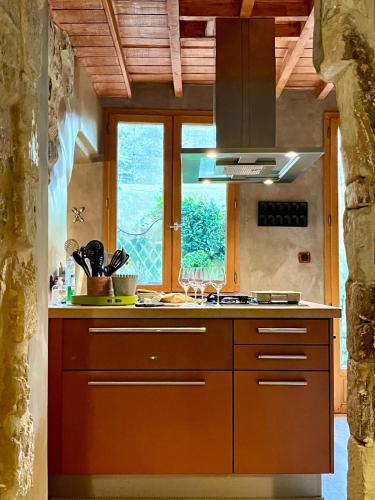 une cuisine avec un évier et une cuisinière dans l'établissement La Maison des Rêves, à Uzès