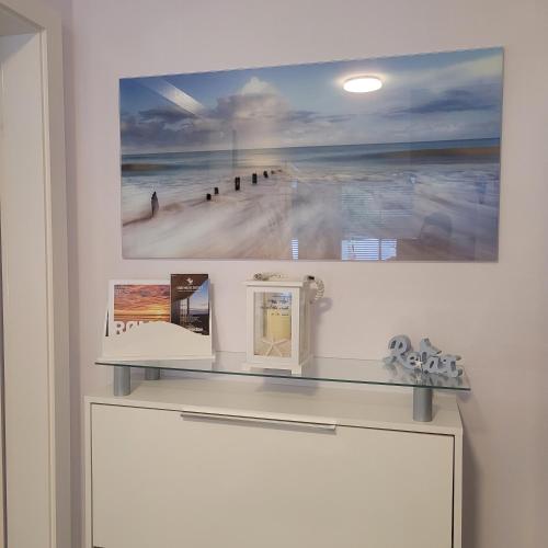 a shelf in a room with a painting on the wall at Strandmuschel in Aventoft