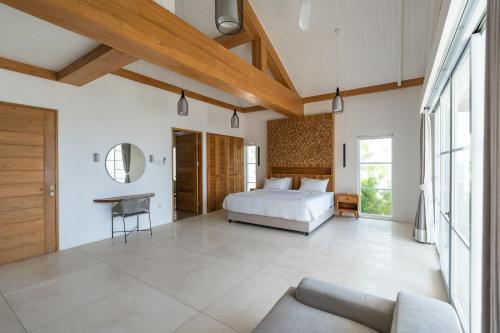 a bedroom with a bed and a couch at Ketewel Beach Villas and Spa in Ketewel