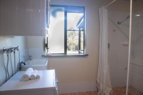 a bathroom with a sink and a tub and a window at #4 Walpole Wilderness Resort chalet - Spa & Forest! in Walpole