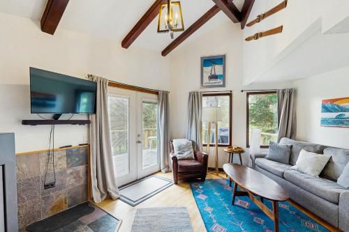 a living room with a couch and a tv at Girdwood Mountain House in Girdwood