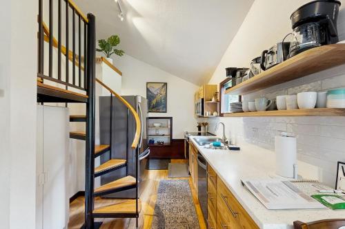 a kitchen with a spiral staircase in a loft at Girdwood Mountain House in Girdwood