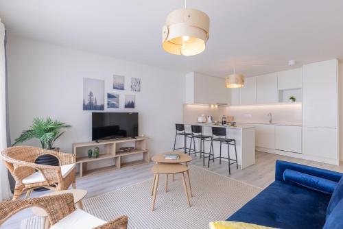 a living room with a blue couch and a kitchen at Peniche Hideout in Peniche