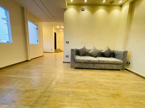 a couch sitting in an empty room in a building at Jewel Grand Pyramids Hotel in Cairo