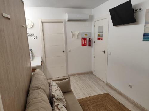 ein Wohnzimmer mit Couch und Fernseher in der Unterkunft Dudi's Peppers in Málaga