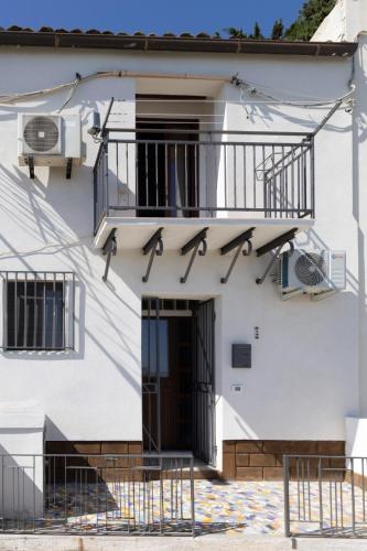 a white building with a balcony and a door at Un Mare di Sogni in Sciacca