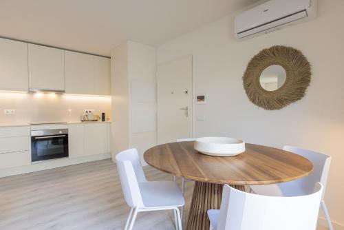 a kitchen and dining room with a wooden table and white chairs at Peniche Hideout in Peniche