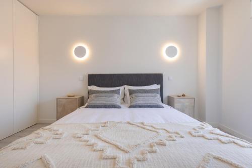 a bedroom with a large white bed with two night stands at Peniche Hideout in Peniche