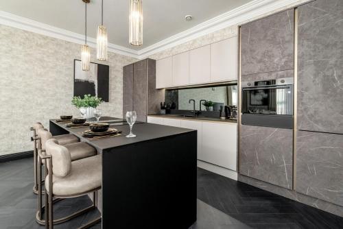 Luxury Old Town Apartment With Private Jacuzzi في إدنبرة: مطبخ مع جزيرة سوداء في مطبخ