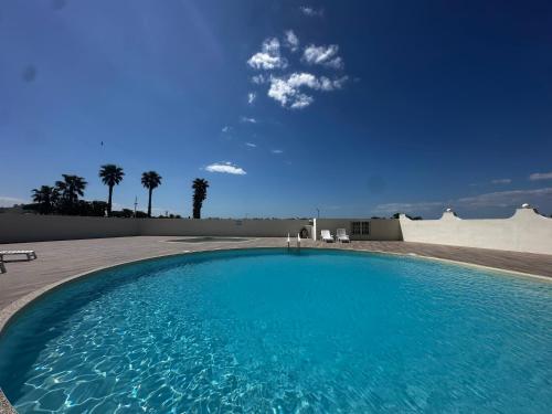 une grande piscine avec de l'eau bleue dans l'établissement Cocon au Grau-du-Roi Calme, lumineux, à 200m de la plage, au Grau-du-Roi