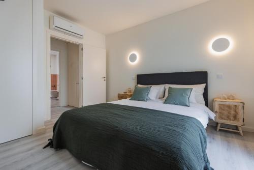 a bedroom with a large bed with green pillows at Peniche Hideout in Peniche