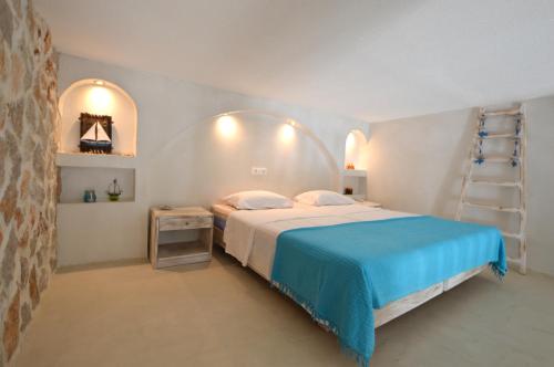 a bedroom with a bed with a blue blanket and a ladder at Kathara Bay Apartments in Faliraki