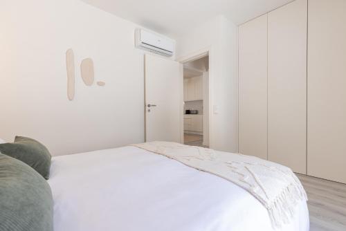 a white bedroom with a bed and a closet at Peniche Hideout in Peniche