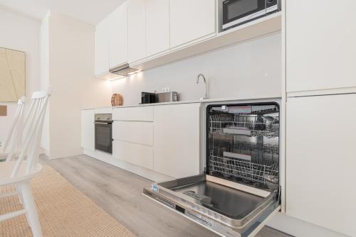 a kitchen with a dishwasher in a white kitchen at Peniche Hideout in Peniche