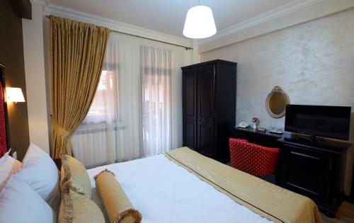a hotel room with a bed and a television at Hotel Galany in Rădăuţi