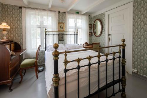 a bedroom with a bed and a desk and a window at Lundins Hotell in Karmøy